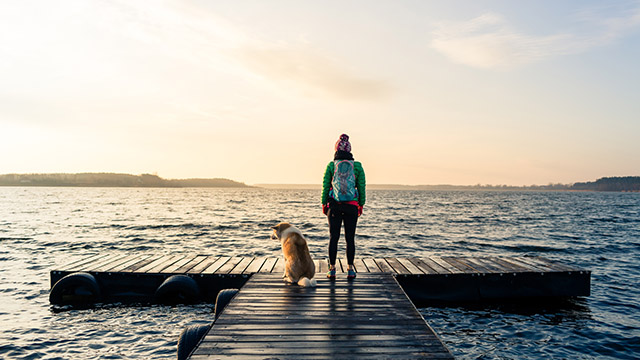 Woman with dog by ocean