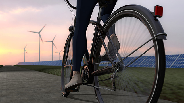 woman on bike in front of windmills